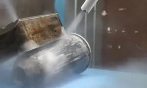 Dysza do czyszczenia suchym lodem strumieniuje na metalowy element, tworząc mgłę.