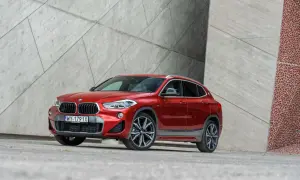 Czerwone BMW X2 na tle nowoczesnej architektury. Wiele osób szuka bmw x2 opinie przed zakupem.