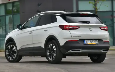 Biały Opel Grandland X z czarnym dachem, z tyłu. Zastanawiasz się, opel grandland x jaki silnik wybrać?