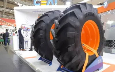 Dwa ogromne opony CEAT z pomarańczowymi felgami na stoisku targowym.