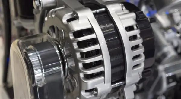 Błyszczący alternator w samochodzie, kluczowy element układu elektrycznego, gotowy do ładowania akumulatora.