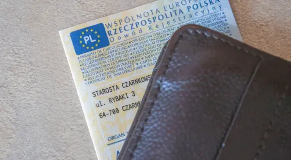 Dowód rejestracyjny pojazdu i brązowy portfel. Czy można zrobić przegląd bez dowodu rejestracyjnego? Dokument zawiera dane pojazdu i adres urzędu.