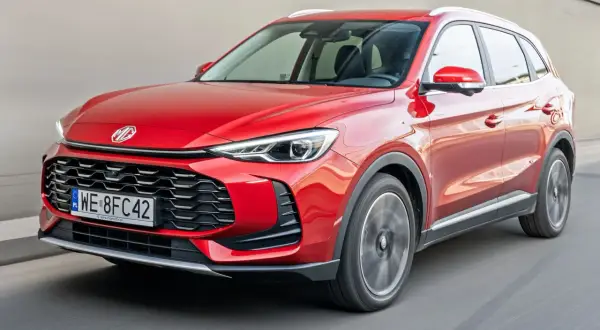 Czerwony auto mg suv pędzi po drodze, jego reflektory ostro świecą.