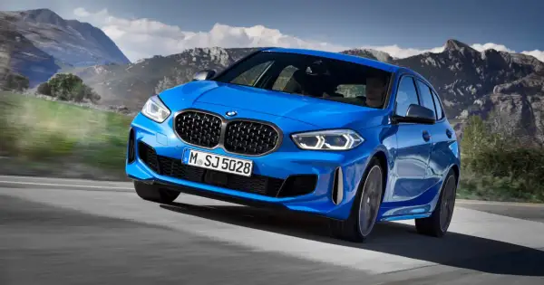 Niebieskie BMW Serii 1 F40 pędzi po górskiej drodze, kierowca skupiony na trasie.