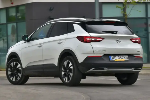 Biały Opel Grandland X z czarnym dachem, z tyłu. Zastanawiasz się, opel grandland x jaki silnik wybrać?