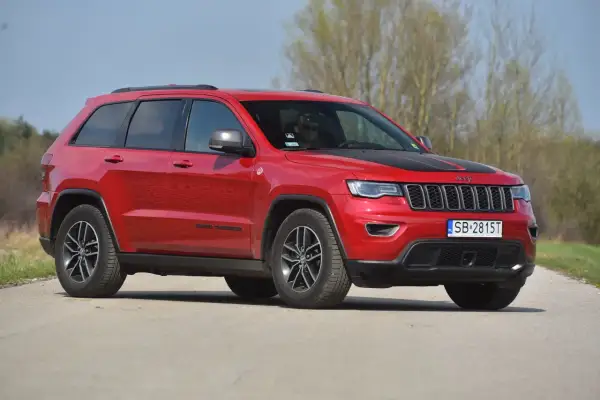 Czerwony Jeep Grand Cherokee na drodze. Poznaj jego imponujące jeep grand cherokee wymiary i możliwości terenowe.