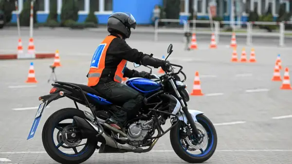 Motocyklista na placu manewrowym, przygotowuje się do egzaminu. Sprawdza, jaka jest prawo jazdy a2 cena, by móc legalnie jeździć.