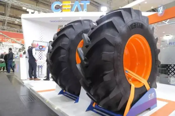 Dwa ogromne opony CEAT z pomarańczowymi felgami na stoisku targowym.