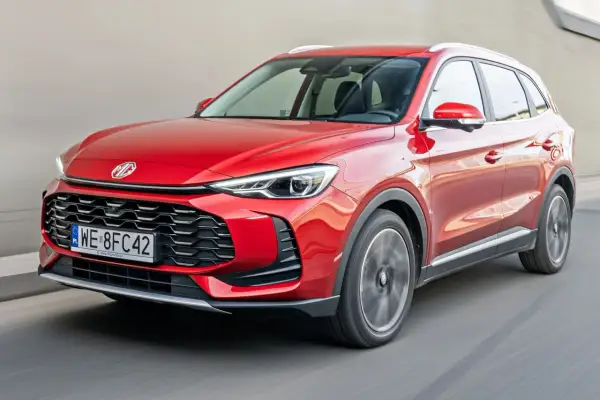 Czerwony auto mg suv pędzi po drodze, jego reflektory ostro świecą.